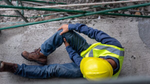 injured construction worker holding knee after workplace accident