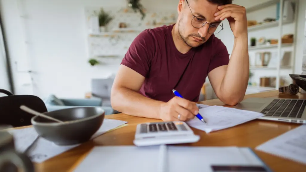 A man calculating his bills. 