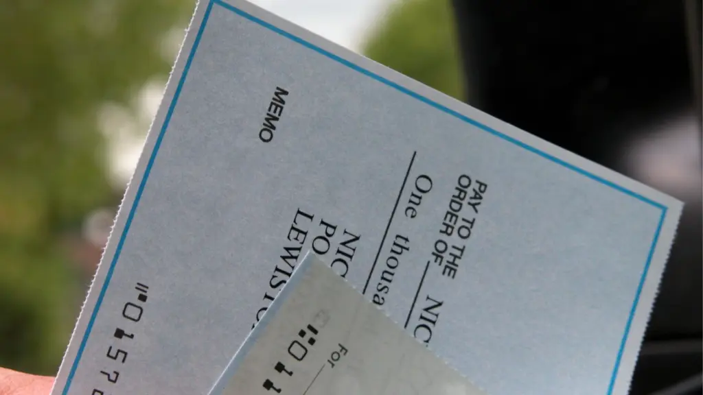 A person holding two checks.