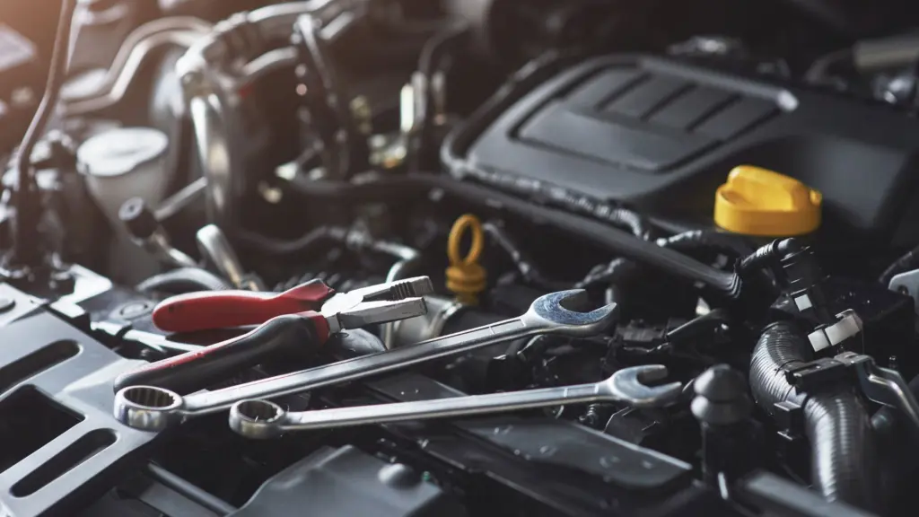 A car engine with tools on top of it. 