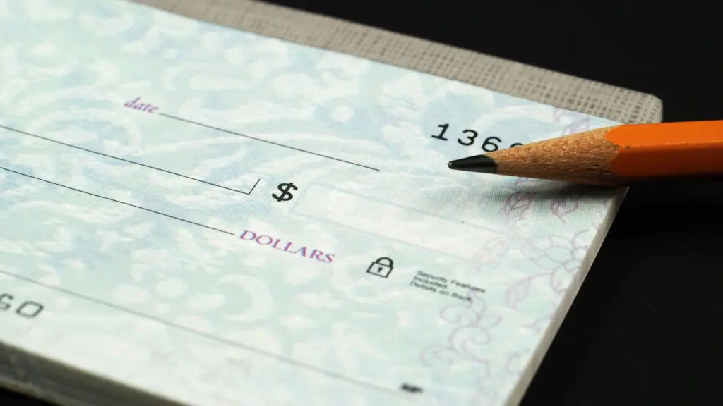 A close up of a check and a pencil. 
