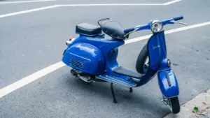 A blue moped parked on the street. 