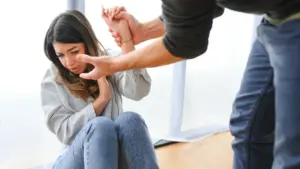 A woman getting forcefully grabbed by a man. 