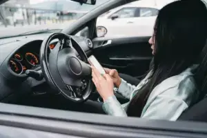 A woman texting while behind the wheel.