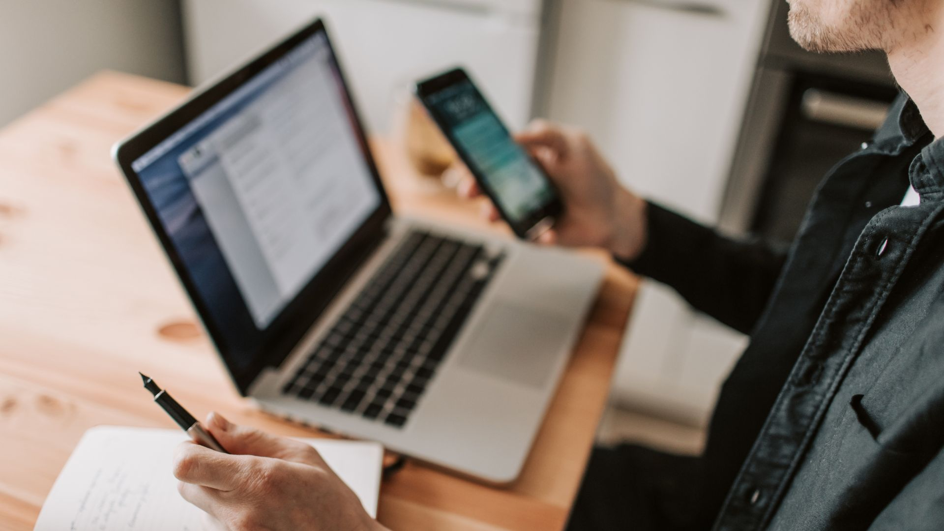 A person researching a problem through their computer and phone. 